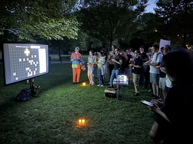 Shapeshifters being projected on a screen in a park at TGW